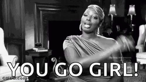 A Woman Is Sitting In A Living Room With Her Arms Outstretched And Says `` You Go Girl '' . GIF