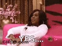 A Woman Is Sitting In A Pink Chair And Saying `` Yes '' . GIF