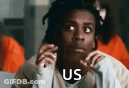 A Woman Is Sitting In A Prison Cell With Her Hands On Her Face And Says `` Us '' . GIF