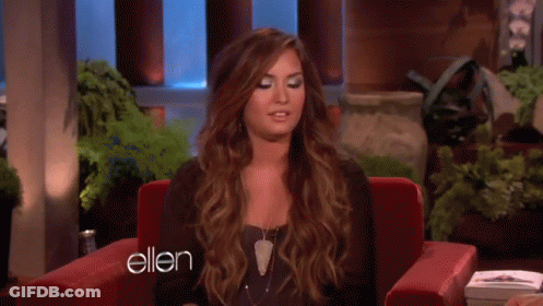 A Woman Is Sitting In A Red Chair With The Word Ellen On The Bottom GIF