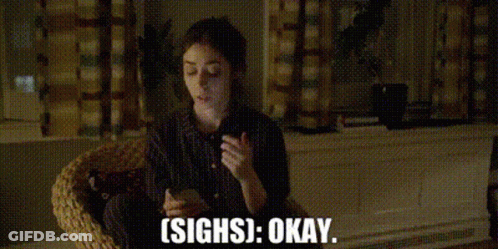 A Woman Is Sitting In A Wicker Chair Holding A Cell Phone And Saying `` Sighs Okay '' . GIF