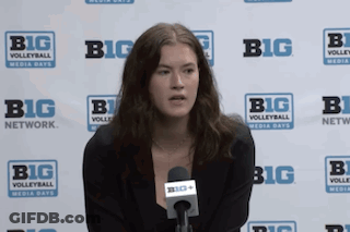 A Woman Is Sitting In Front Of A Big Network Sign GIF