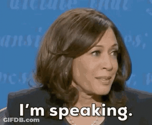 A Woman Is Sitting In Front Of A Blue Background And Says I 'M Speaking . GIF