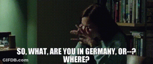 A Woman Is Sitting In Front Of A Bookshelf With The Words So What Are You In Germany Or Where Written Below Her GIF