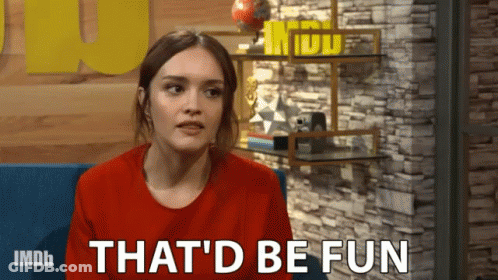 A Woman Is Sitting In Front Of A Brick Wall And Says That 'D Be Fun GIF