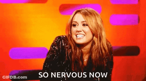 A Woman Is Sitting In Front Of A Colorful Background And Smiling . GIF