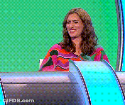 A Woman Is Sitting In Front Of A Green Screen . GIF