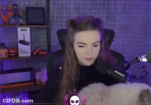 A Woman Is Sitting In Front Of A Microphone And A Box That Says ' Shure ' On It . GIF