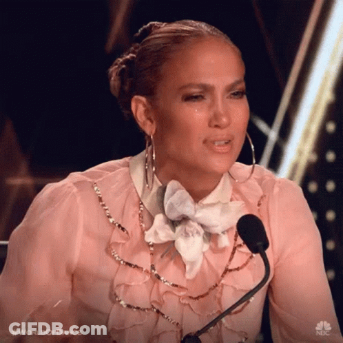 A Woman Is Sitting In Front Of A Microphone And Crying . GIF