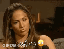 A Woman Is Sitting In Front Of A Microphone And Saying Okay GIF