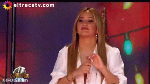 A Woman Is Sitting In Front Of A Microphone On A Television Screen With Eltrecetv.com Written On It GIF