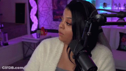A Woman Is Sitting In Front Of A Microphone . GIF