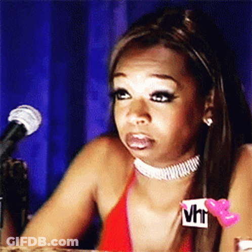 A Woman Is Sitting In Front Of A Microphone Wearing A Choker That Says Vh1 On It GIF