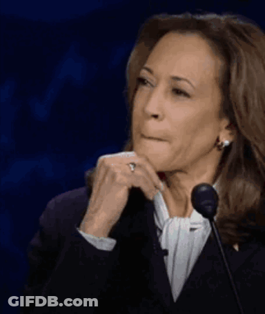 A Woman Is Sitting In Front Of A Microphone With Her Hand On Her Chin And A Ring On Her Finger . GIF