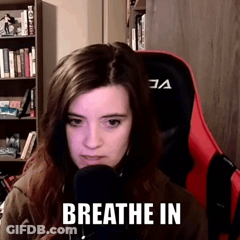 A Woman Is Sitting In Front Of A Microphone With The Words Breathe In On Her Face . GIF