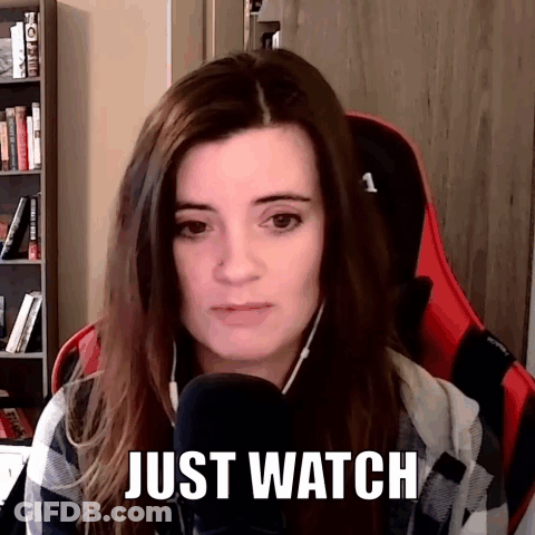 A Woman Is Sitting In Front Of A Microphone With The Words Just Watch Above Her Head . GIF