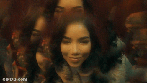 A Woman Is Sitting In Front Of A Mirror With Her Eyes Closed And A Blurry Background . GIF