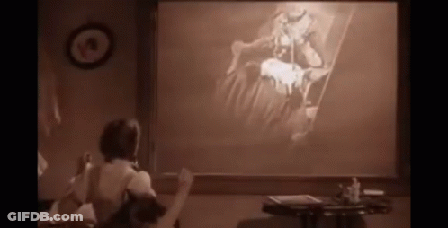 A Woman Is Sitting In Front Of A Projector Screen With A Picture On It GIF