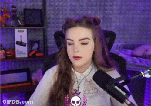 A Woman Is Sitting In Front Of A Shure Microphone In A Recording Studio . GIF
