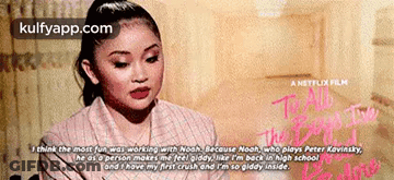 A Woman Is Sitting In Front Of A Sign That Says I Think The Most Fun Was Working With Noah GIF