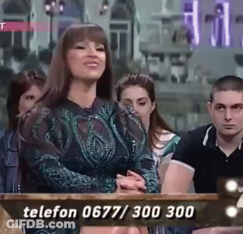 A Woman Is Sitting In Front Of A Table With A Phone Number Written On It . GIF