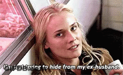 A Woman Is Sitting In Front Of A Window Holding A Cell Phone And Saying I 'M Just Trying To Hide GIF
