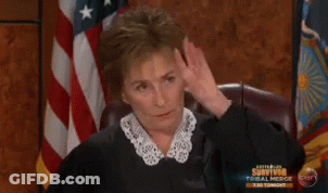 A Woman Is Sitting In Front Of An American Flag And A Sign That Says Survivor Tonight GIF