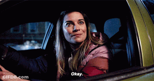 A Woman Is Sitting In The Back Seat Of A Car And Says Okay . GIF