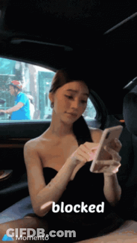 A Woman Is Sitting In The Back Seat Of A Car Looking At Her Phone And The Word Blocked Is On The Bottom Right GIF