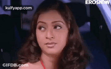 A Woman Is Sitting In The Back Seat Of A Car . GIF