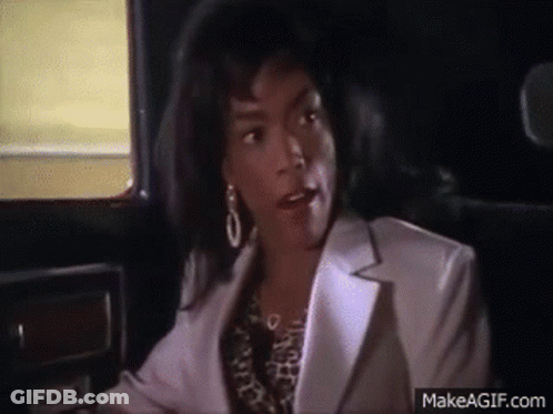 A Woman Is Sitting In The Back Seat Of A Car Talking To Someone . GIF