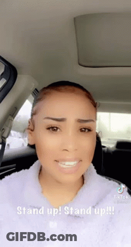A Woman Is Sitting In The Back Seat Of A Car With A Caption That Says Stand Up ! Stand Up !! GIF