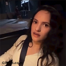 A Woman Is Sitting In The Back Seat Of A Car With A Seat Belt . GIF