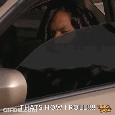 A Woman Is Sitting In The Driver 'S Seat Of A Car And Looking Out The Window . GIF