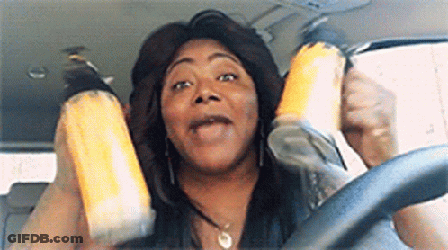 A Woman Is Sitting In The Driver 'S Seat Of A Car Holding A Can Of Soda . GIF