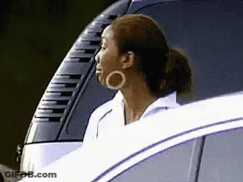 A Woman Is Sitting In The Driver 'S Seat Of A Car . GIF