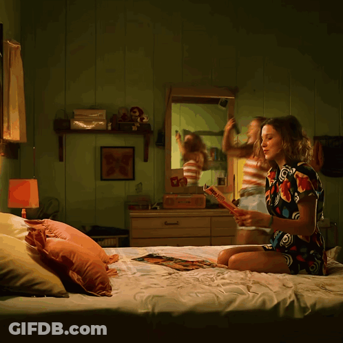 A Woman Is Sitting On A Bed Reading A Book Called " A Brief History Of The World " GIF