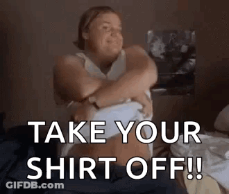 A Woman Is Sitting On A Bed Taking Off Her Shirt And Says `` Take Your Shirt Off ! '' GIF