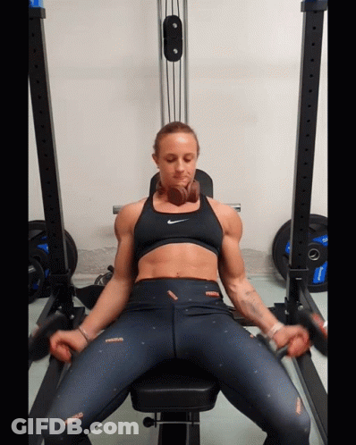 Woman Sitting On Gym Bench In Nike Top GIF