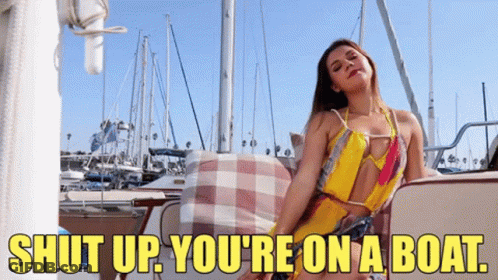 A Woman Is Sitting On A Boat With The Words Shut Up You 'Re On A Boat GIF
