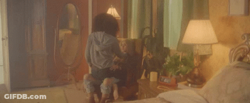 A Woman Is Sitting On A Chair With A Child In A Bedroom . GIF