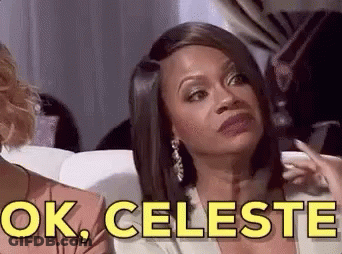 A Woman Is Sitting On A Couch And Making A Funny Face While Talking To Another Woman . GIF