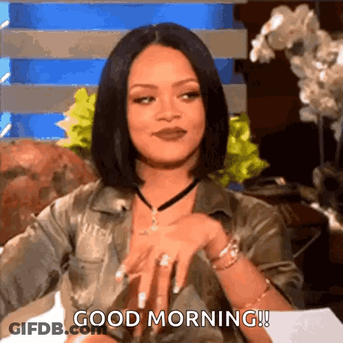 A Woman Is Sitting On A Couch And Saying `` Good Morning '' While Wearing A Choker . GIF