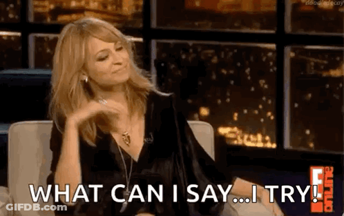 A Woman Is Sitting On A Couch And Saying What Can I Say ... I Try ! GIF