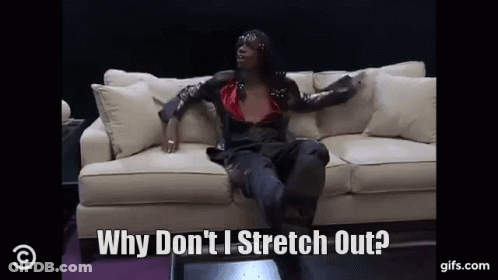 A Woman Is Sitting On A Couch And Saying Why Don 'T I Stretch Out GIF