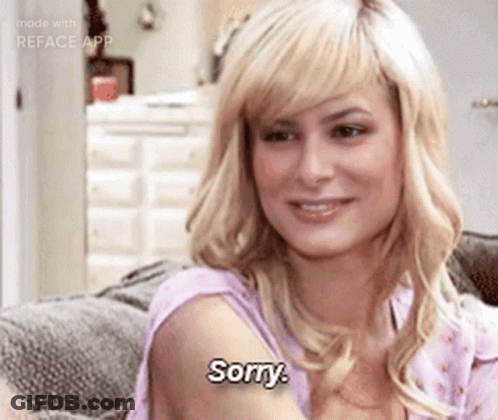 A Woman Is Sitting On A Couch And Says " Sorry " GIF