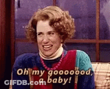 A Woman Is Sitting On A Couch And Smiling While Saying Oh My Goooood , A Baby . GIF