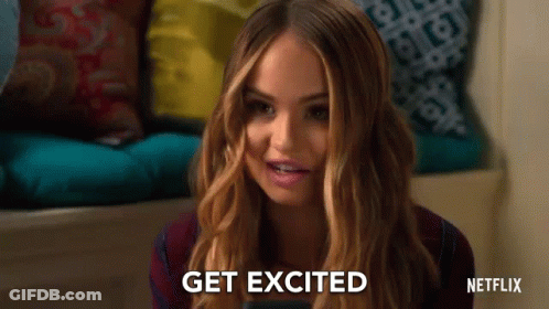 A Woman Is Sitting On A Couch Holding A Cell Phone And Smiling . GIF