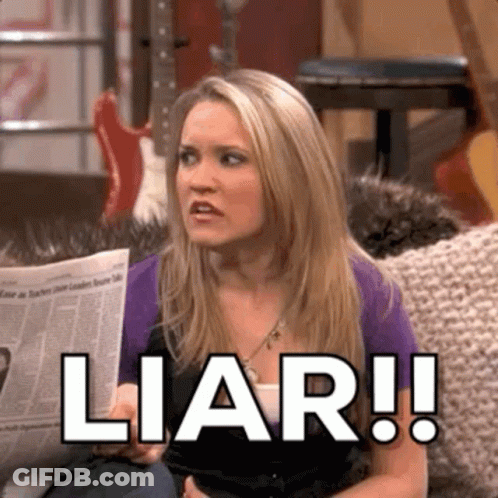 A Woman Is Sitting On A Couch Holding A Newspaper And Saying Liar . GIF