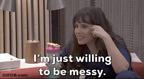 A Woman Is Sitting On A Couch Holding A Shaker And Saying I 'M Just Willing To Be Messy GIF